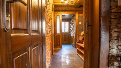 a hallway with a wooden door and a brick wall at Jaworowa Osada in Brenna