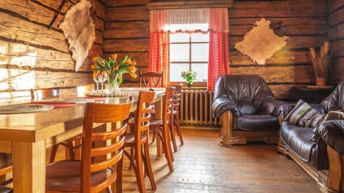 a dining room with a table and leather chairs at Jaworowa Osada in Brenna
