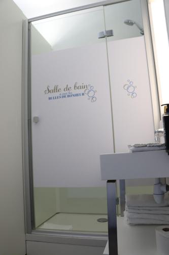 a shower stall with a glass door with a sign on it at First Inn Hotel Blois in Blois