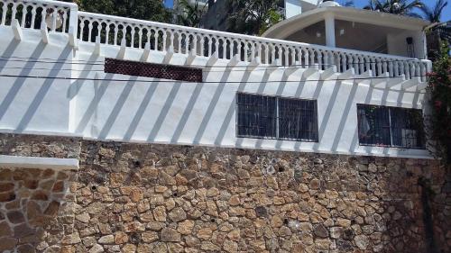 a white awning on top of a stone wall at Villa Guitarron gran terraza vista espectacular 6 huespedes piscina gigante in Acapulco