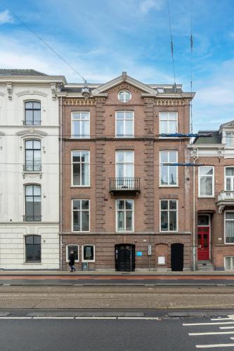 a large brick building on the side of a street at Numa Amsterdam Helmers in Amsterdam