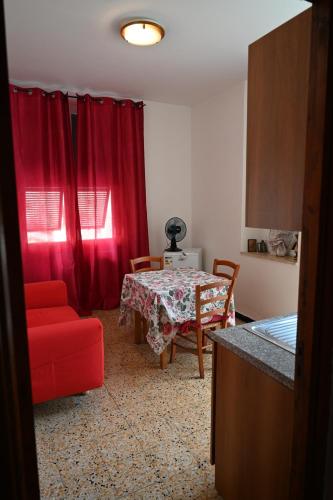a living room with a table and red curtains at Il Capriolo in Tavernelle