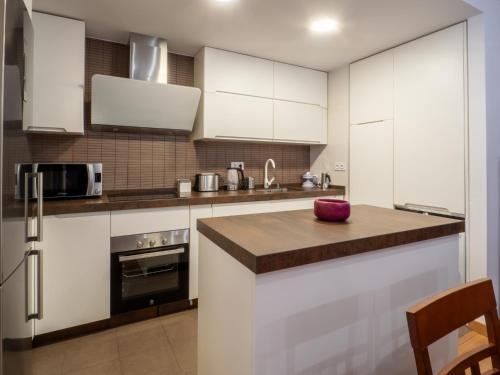 a kitchen with white cabinets and a red bowl on a counter at BHost - María Auxiliadora in Córdoba