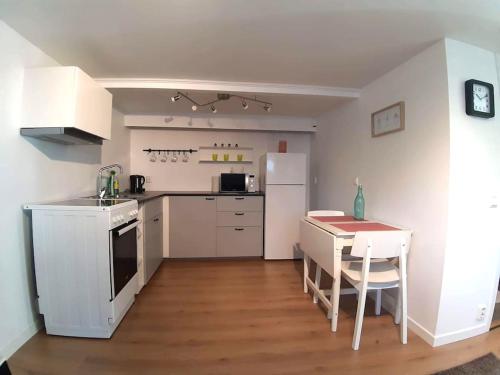 Il comprend une cuisine équipée d'une table et d'un réfrigérateur blanc. dans l'établissement By the sea apartment, à Stavanger