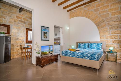 um quarto com uma cama numa parede de tijolos em Casa vacanze Peperoncino em Castellammare del Golfo