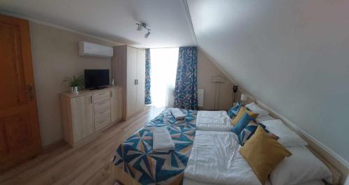 a bedroom with a bed with a blue and white comforter at Jázmin Apartman in Tihany
