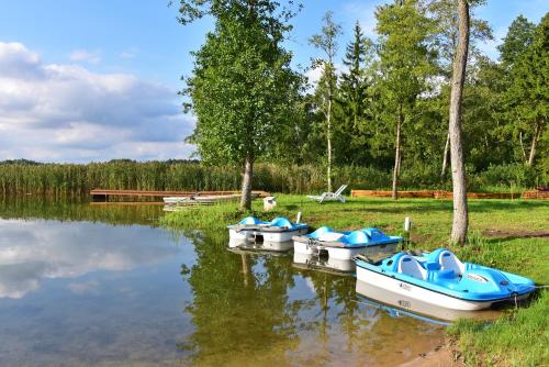 a group of boats sitting on the water at Namas su vaizdu į ežerą "Giliaus Nendrė" in Tytuvėnai