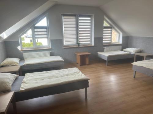 um quarto com quatro camas e janelas e uma mesa em HGS Home Noclegi PARKING em Gorzów Wielkopolski