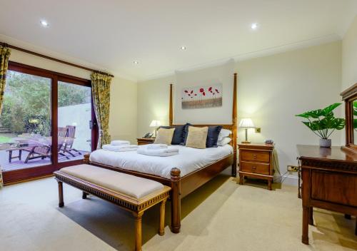 a bedroom with a large bed and a desk at Poppy Cottage - Cornwall in Saint Wenn
