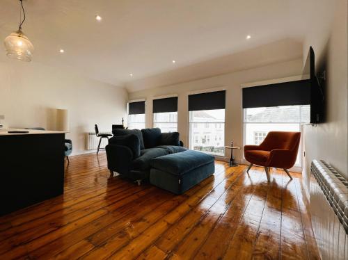 a living room with a couch and a chair at Cross Street Apartment in Ryde