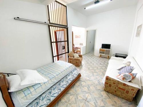 a bedroom with a bed and a couch in a room at Casinha Quadra Mar a 10 min do Beto Carrero! in Penha
