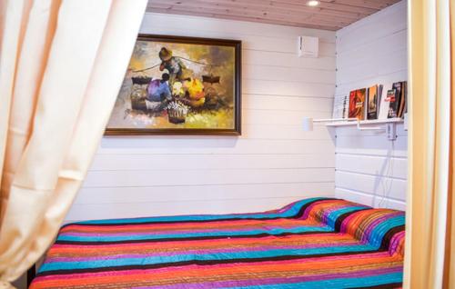 a bed in a room with a painting on the wall at Cosy cottage by the south coast in Trelleborg