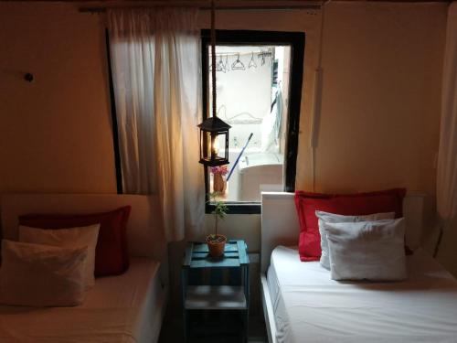 a room with two beds with a window and a table at Terracota Mirador Filandia in Filandia