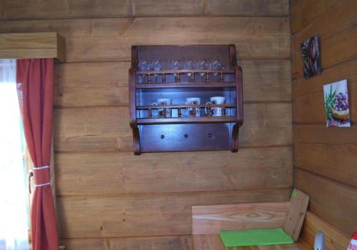a wooden wall with a shelf with glasses on it at Jaworowa Osada in Brenna