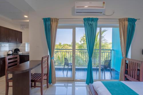 eine Küche und ein Esszimmer mit Blick auf einen Balkon in der Unterkunft BnB Homes, Technopark, Trivandrum in Kazhakuttam