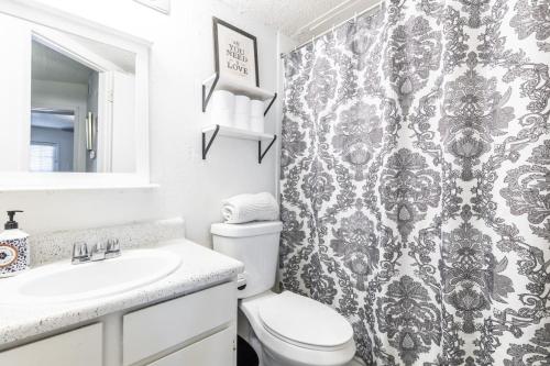 a bathroom with a toilet and a shower curtain at COZY LONG TERM APT WITH POOL ACCESS IN DFW in Dallas