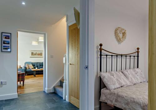 a bedroom with a bed and a living room at Wisteria House in Camelford