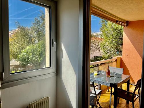 Habitación con mesa y ventana grande. en Les Pins YourHostHelper, en Cagnes-sur-Mer