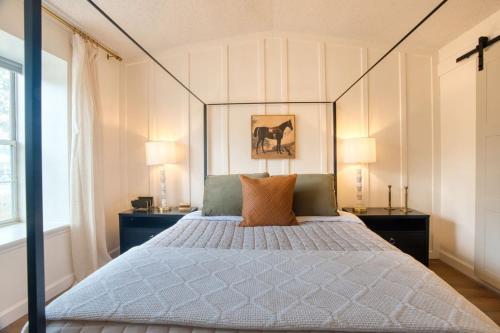 a bedroom with a canopy bed with two tables and two lamps at Southern Travel - Charming 3 Bedroom in Moultrie