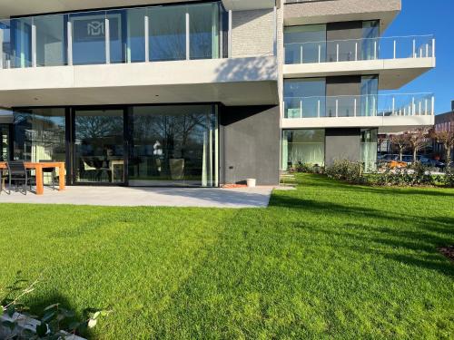 a large building with a lawn in front of it at Logies La Parmentière in De Panne