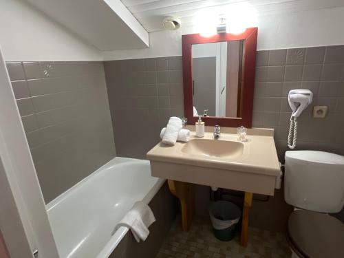 a bathroom with a sink and a toilet and a tub at Hôtel Restaurant La Pendine in Puy-Saint-Vincent
