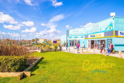 Un gruppo di persone che camminano davanti a un edificio di WW259 Parkdean, Camber Sands a Camber