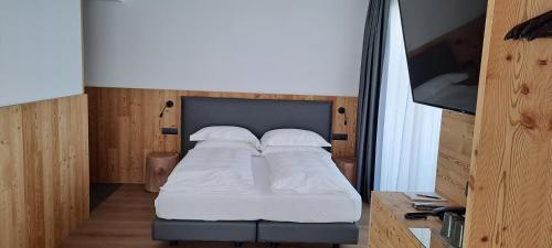 a bedroom with a bed with white sheets and pillows at Vetta Alpine Relax in Livigno