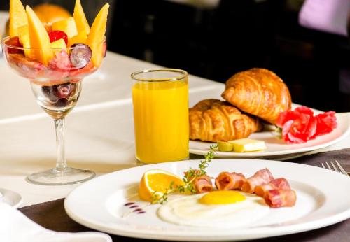 a table with two plates of food and a glass of orange juice at Hotel Britania Miraflores in Lima