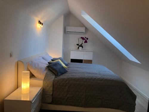 a bedroom with a bed and a table with a lamp at Apartmán X28 in Mikulov