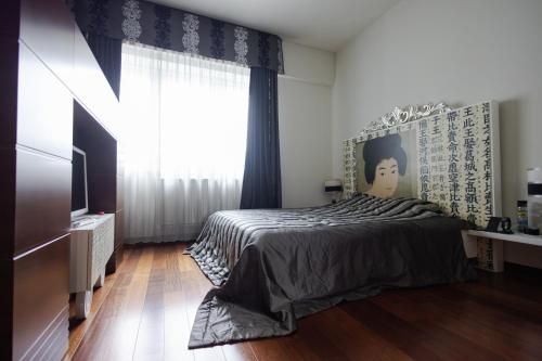 a bedroom with a bed and a large window at Business Apartment in Belgrade