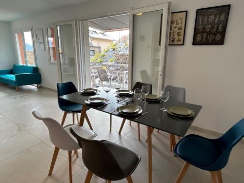 une salle à manger avec une table et des chaises noires dans l'établissement La Villa des Cimes, à Pelleautier