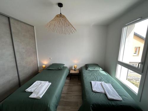 two twin beds in a room with a window at La Villa des Cimes in Pelleautier