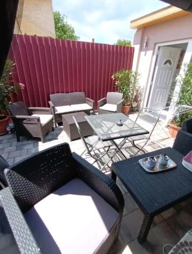 a patio with chairs and tables and a red fence at Flower 3 free parking in Siófok