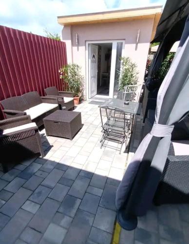a patio with chairs and tables on a house at Flower 3 free parking in Siófok