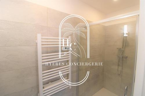 una doccia in bagno con un cartello sul muro di Appartements Plage des oursinières Pieds dans l'eau Plage-Parking-Wifi BY HC a Le Pradet