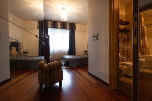 a room with a bedroom with a bed and a chair at Business Apartment in Belgrade