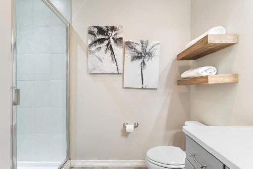 a bathroom with two palm trees prints on the wall at Living In Luxury in Pensacola