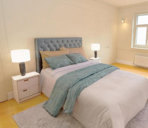 a bedroom with a large bed with two lamps at Townhouse near Spitalfields Market in London