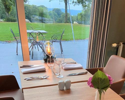 a wooden table with wine glasses on top of it at Hotel et restaurant Le Clos De La Prairie in Gouy-Saint-André