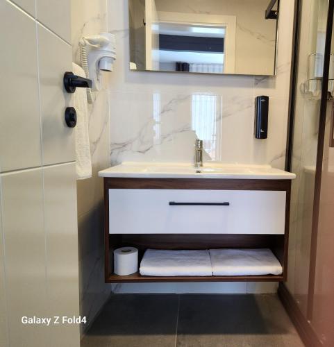 a bathroom with a sink and a mirror at Lulubay Rooms & Suites in Kusadası