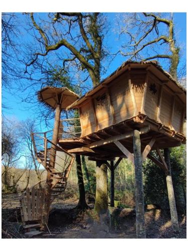 a tree house in front of a tree at Les hébergements insolites de Quénécan in Perret