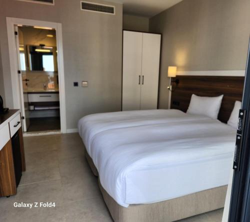 a bedroom with a large bed and a bathroom at Lulubay Rooms & Suites in Kusadası