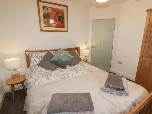 a bedroom with a bed with two pillows on it at Le Durkestrete Cellar in Haverfordwest