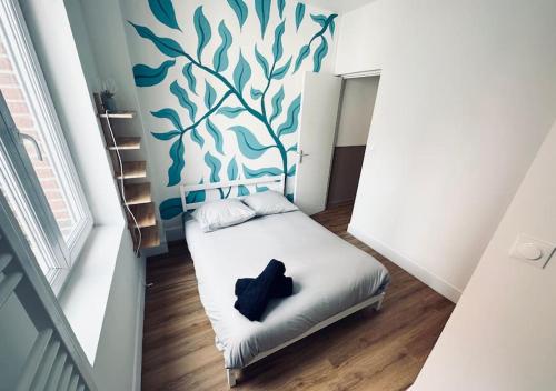 - un petit lit dans une chambre dotée d'un mur bleu dans l'établissement T3 moderne et neuf à 5 min Lille-Centre, à Lille