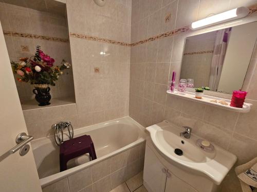 une salle de bain avec un lavabo et une baignoire et un lavabo dans l'établissement Palmeraie 136- Vue mer- piscine en résidence, à Sari-Solenzara