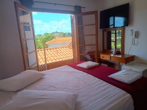 a bedroom with a bed and a large window at Pousada Casablanca Águas de São Pedro in Águas de São Pedro