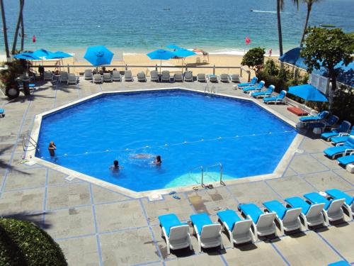 a pool with people in it next to the beach at Hotel Acapulco Malibu in Acapulco