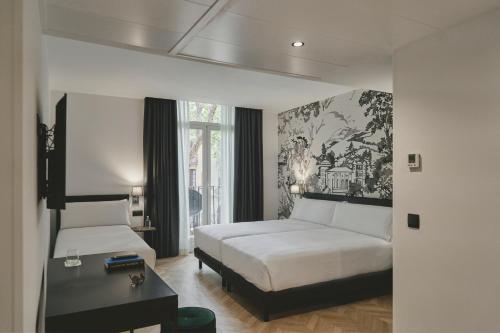 a bedroom with a bed and a desk and a bed sidx sidx sidx at Oriente Atiram in Barcelona