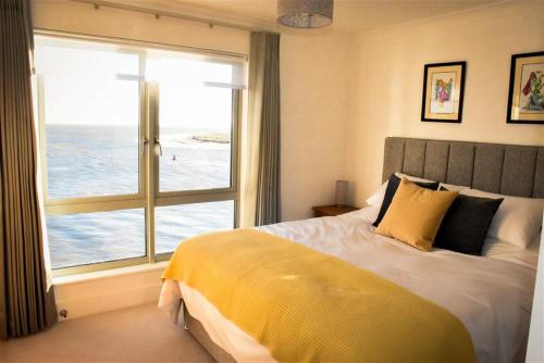 a bedroom with a bed with a view of the ocean at The Point in Exmouth