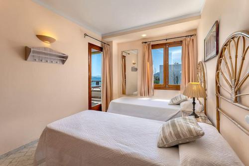 a hotel room with two beds and a window at Llenaire 2, Sea view, pool, AC in Port de Pollensa